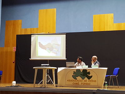 Av Cam Fondo de Castello: Imagen de la conferencia y en pantalla las partidas de Castell de la Plana
